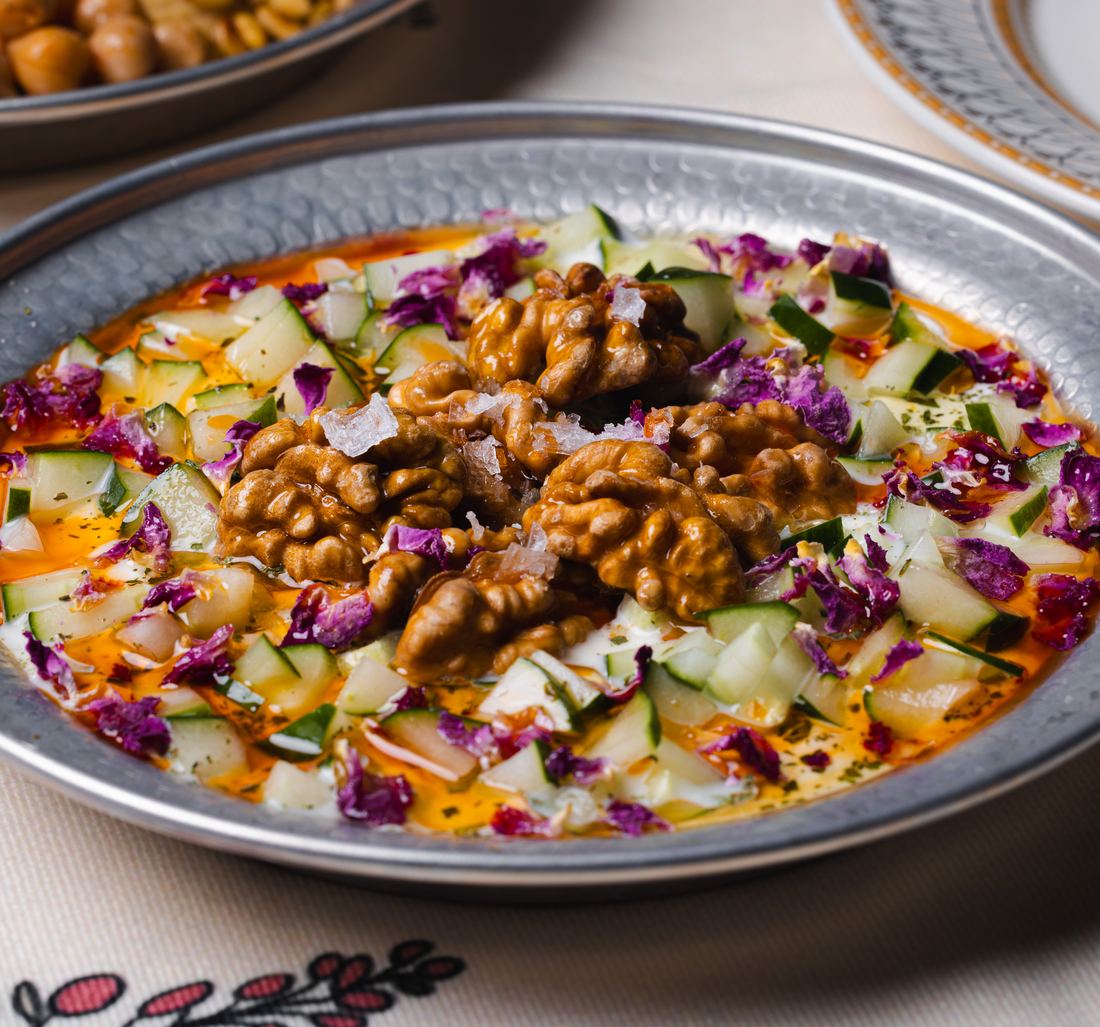Mast o khiar: strained yoghurt with cucumber, rose petals and walnuts on a hammered plate
