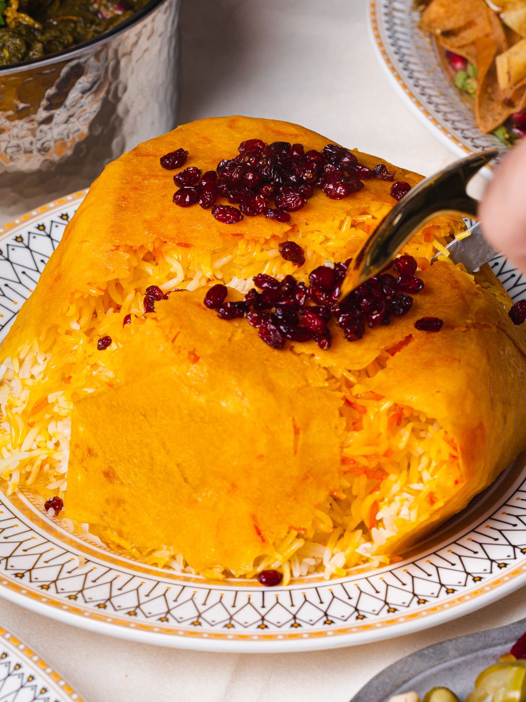 A saffron rice dome with barberries, opened at the table