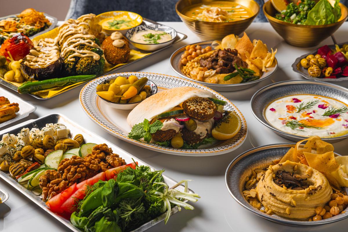 A full mezze spread across the marble: dolma, falafel, hummus and pickles