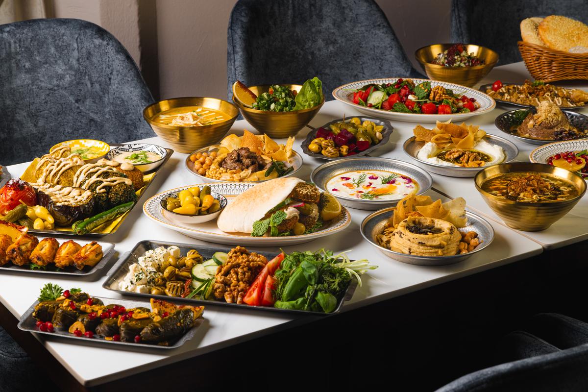 The table at Shirazi, laid edge to edge with mezze and stews
