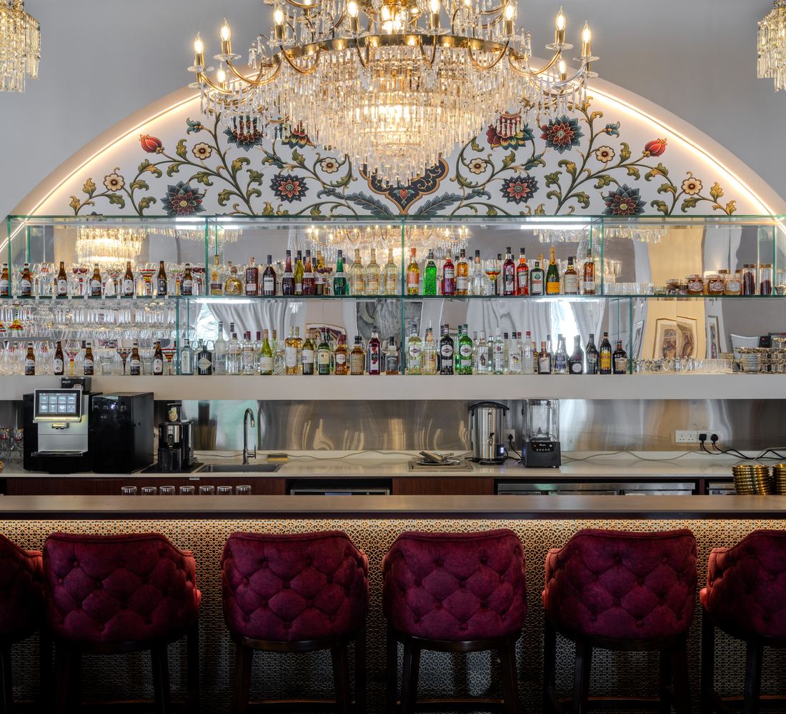 The illuminated floral arch over the bar, lined with crystal chandeliers