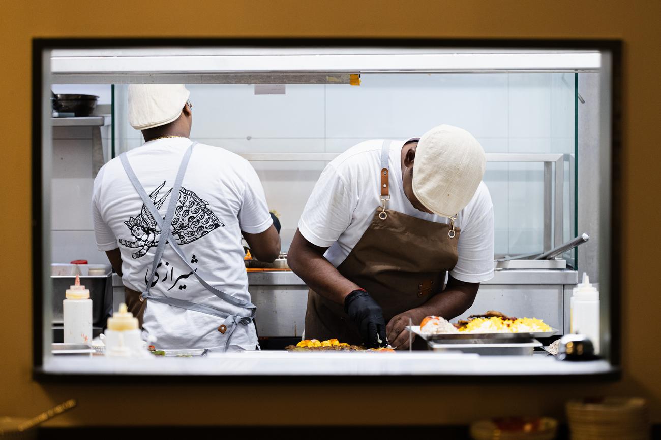 The kitchen pass: two chefs plating through the window